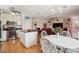 Open-concept kitchen and living room with hardwood floors and modern decor and white rattan furniture at 3227 Rose Arbor Dr, Hernando Beach, FL 34607