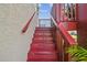 Exterior stairs of the home, featuring bold color scheme and tropical landscaping at 3227 Rose Arbor Dr, Hernando Beach, FL 34607