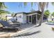 Backyard with lounge chairs, deck, screened-in porch, pond and tropical landscaping at 328 Tallahassee Ne Dr, St Petersburg, FL 33702