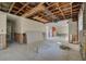 Spacious, partially renovated living area with exposed ceiling beams, large windows, and open doorway at 328 Tallahassee Ne Dr, St Petersburg, FL 33702