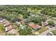 An aerial view of a quaint neighborhood with mature trees and a golf course in the distance at 35145 Whispering Oaks Blvd, Dade City, FL 33523