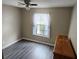 Bedroom showcasing light, neutral walls, wood floors, bright window and ceiling fan at 35145 Whispering Oaks Blvd, Dade City, FL 33523