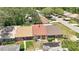 An aerial view of a charming single-story home with a manicured lawn and mature trees at 35145 Whispering Oaks Blvd, Dade City, FL 33523