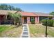 Charming single-story home with a manicured lawn, stepping stone walkway, and beautiful landscaping at 35145 Whispering Oaks Blvd, Dade City, FL 33523