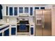 Modern kitchen with sleek stainless steel appliances, white countertops, and bold blue and white cabinets at 35145 Whispering Oaks Blvd, Dade City, FL 33523