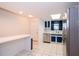 Well-lit kitchen area with bright white tile, stainless steel dishwasher, and a breakfast bar at 35145 Whispering Oaks Blvd, Dade City, FL 33523