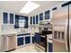 Contemporary kitchen with stainless steel appliances, bright white counters, and white and blue cabinets at 35145 Whispering Oaks Blvd, Dade City, FL 33523