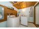 Practical laundry room with washer, dryer, hot water tank, and ample shelving for storage at 35145 Whispering Oaks Blvd, Dade City, FL 33523