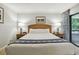 Bright bedroom with king bed, matching lamps, and access to a balcony at 36750 Us 19 N # 07208, Palm Harbor, FL 34684
