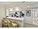 Modern white kitchen with stainless steel appliances, breakfast bar, and open access to the bathroom at 36750 Us 19 N # 07208, Palm Harbor, FL 34684
