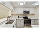 Modern kitchen with stainless steel appliances and white cabinets, with a stylish design at 36750 Us 19 N # 07208, Palm Harbor, FL 34684