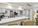 Bright kitchen featuring white cabinetry, modern appliances, and a breakfast bar open to living area at 36750 Us 19 N # 07208, Palm Harbor, FL 34684