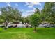 Overhead scenic view of a parking lot surrounded by mature trees and lush green grass at 36750 Us 19 N # 07208, Palm Harbor, FL 34684