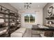Bright home office with built-in shelving, a modern desk, and a comfortable bench for a productive workspace at 37224 Clinch Cir, Zephyrhills, FL 33540