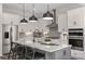 Well-equipped kitchen with a center island, stainless steel appliances, and sleek white cabinetry for a modern aesthetic at 37224 Clinch Cir, Zephyrhills, FL 33540