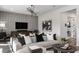 Comfortable living room featuring stylish decor, a large sectional sofa, and a contemporary entertainment center at 37224 Clinch Cir, Zephyrhills, FL 33540