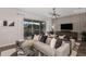 Stylish living room with a comfortable sectional sofa, sleek entertainment center, and large windows for ample natural light at 37224 Clinch Cir, Zephyrhills, FL 33540