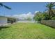 Expansive backyard with lush green grass, a fire pit, and fenced perimeter, ideal for outdoor activities and privacy at 402 12Th Sw St, Ruskin, FL 33570