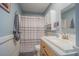 Standard bathroom with a shower/tub combo, gray striped shower curtain, and a vanity at 402 12Th Sw St, Ruskin, FL 33570