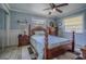 Comfortable bedroom featuring a four-poster bed, ceiling fan and wood-look flooring at 402 12Th Sw St, Ruskin, FL 33570