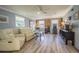 Living room with recliner seating, wood-look flooring, windows, and wainscoting at 402 12Th Sw St, Ruskin, FL 33570