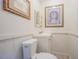 Small powder room with a wood paneled walls, toilet, sink and decorative art at 402 12Th Sw St, Ruskin, FL 33570