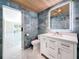 Modern bathroom with blue tile walls, a wooden ceiling, an illuminated mirror, and a white vanity at 4291 Neptune Se Dr, St Petersburg, FL 33705