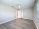 Well-lit bedroom with ceiling fan, neutral walls, white trim and wood-look flooring at 4291 Neptune Se Dr, St Petersburg, FL 33705