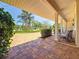 Covered carport showcasing brick flooring, classic pillars, and outdoor seating, framed by lush greenery at 4291 Neptune Se Dr, St Petersburg, FL 33705