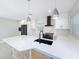 Modern kitchen featuring white cabinets, black appliances, and stylish pendant lighting at 4291 Neptune Se Dr, St Petersburg, FL 33705