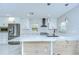 Open kitchen features white cabinets, stainless steel appliances, and a spacious island with seating at 4291 Neptune Se Dr, St Petersburg, FL 33705