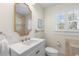 Bathroom vanity with marble countertop, decorative mirror, and window with privacy shutters at 455 18Th Ne Ave, St Petersburg, FL 33704