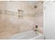 Bathtub and shower with elegant marble tiling and a built-in shelf at 455 18Th Ne Ave, St Petersburg, FL 33704