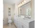 Bright bathroom featuring a double vanity, framed mirror, and a separate toilet at 455 18Th Ne Ave, St Petersburg, FL 33704