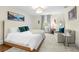 Bright bedroom featuring a white bed, plush carpet, and a cozy sitting area at 455 18Th Ne Ave, St Petersburg, FL 33704
