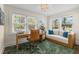Bright home office featuring a wooden desk, stylish chair, daybed with blue pillows, and lots of natural light at 455 18Th Ne Ave, St Petersburg, FL 33704