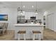 Modern kitchen featuring quartz countertops, stainless steel appliances, an island with bar seating, and light wood floors at 461 Celeste St, Port Charlotte, FL 33954