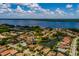 Panoramic aerial view of houses with tile roofs near a lake, set against a backdrop of lush greenery and water views at 4611 Grand Preserve Pl, Palm Harbor, FL 34684