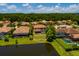 Aerial view of a home with a screened-in pool, overlooking a serene lake surrounded by lush greenery at 4611 Grand Preserve Pl, Palm Harbor, FL 34684