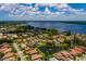Stunning aerial view of a neighborhood with homes surrounding a lake, offering scenic water views and lush greenery at 4611 Grand Preserve Pl, Palm Harbor, FL 34684