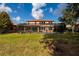 A large backyard shows the screened pool, lush lawn, and well-maintained exterior of the house at 4611 Grand Preserve Pl, Palm Harbor, FL 34684