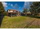 Expansive backyard featuring lush green grass, a screened pool, and a charming home exterior at 4611 Grand Preserve Pl, Palm Harbor, FL 34684