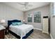 Cozy bedroom with wood-look flooring, neutral paint, and natural light streaming through large windows at 4611 Grand Preserve Pl, Palm Harbor, FL 34684