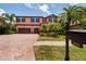 Charming two-story home with a brick driveway, lush landscaping, and a two-car garage at 4611 Grand Preserve Pl, Palm Harbor, FL 34684