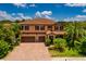 Beautiful two-story home boasting a brick driveway, tile roof, two-car garage, and mature palm trees at 4611 Grand Preserve Pl, Palm Harbor, FL 34684