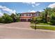 Attractive two-story home with a brick driveway, tile roof, two-car garage, and mature palm trees at 4611 Grand Preserve Pl, Palm Harbor, FL 34684