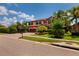 Charming two-story home with a well-manicured lawn and a brick driveway, surrounded by lush landscaping and palm trees at 4611 Grand Preserve Pl, Palm Harbor, FL 34684
