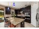 A well-equipped kitchen with dark cabinets, granite countertops, a center island and stainless steel appliances at 4611 Grand Preserve Pl, Palm Harbor, FL 34684