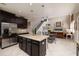 An open concept kitchen with dark cabinets, granite island, stainless appliances and an adjoining dining and living space at 4611 Grand Preserve Pl, Palm Harbor, FL 34684