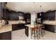 Elegant kitchen featuring dark cabinetry, granite countertops, a center island, and stainless steel appliances at 4611 Grand Preserve Pl, Palm Harbor, FL 34684